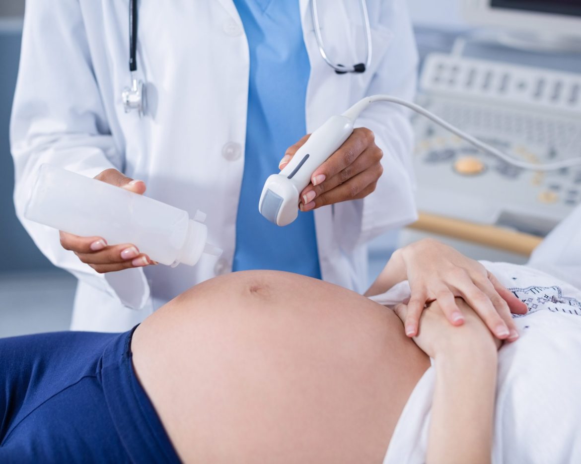 Pregnant woman receiving a ultrasound scan on the stomach in hospital