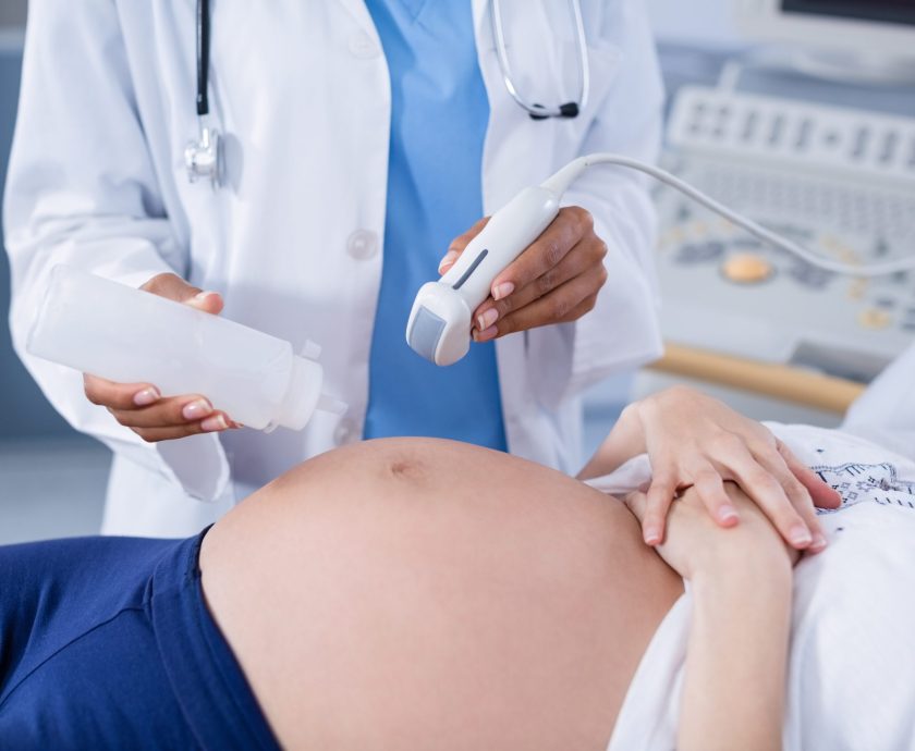 Pregnant woman receiving a ultrasound scan on the stomach in hospital