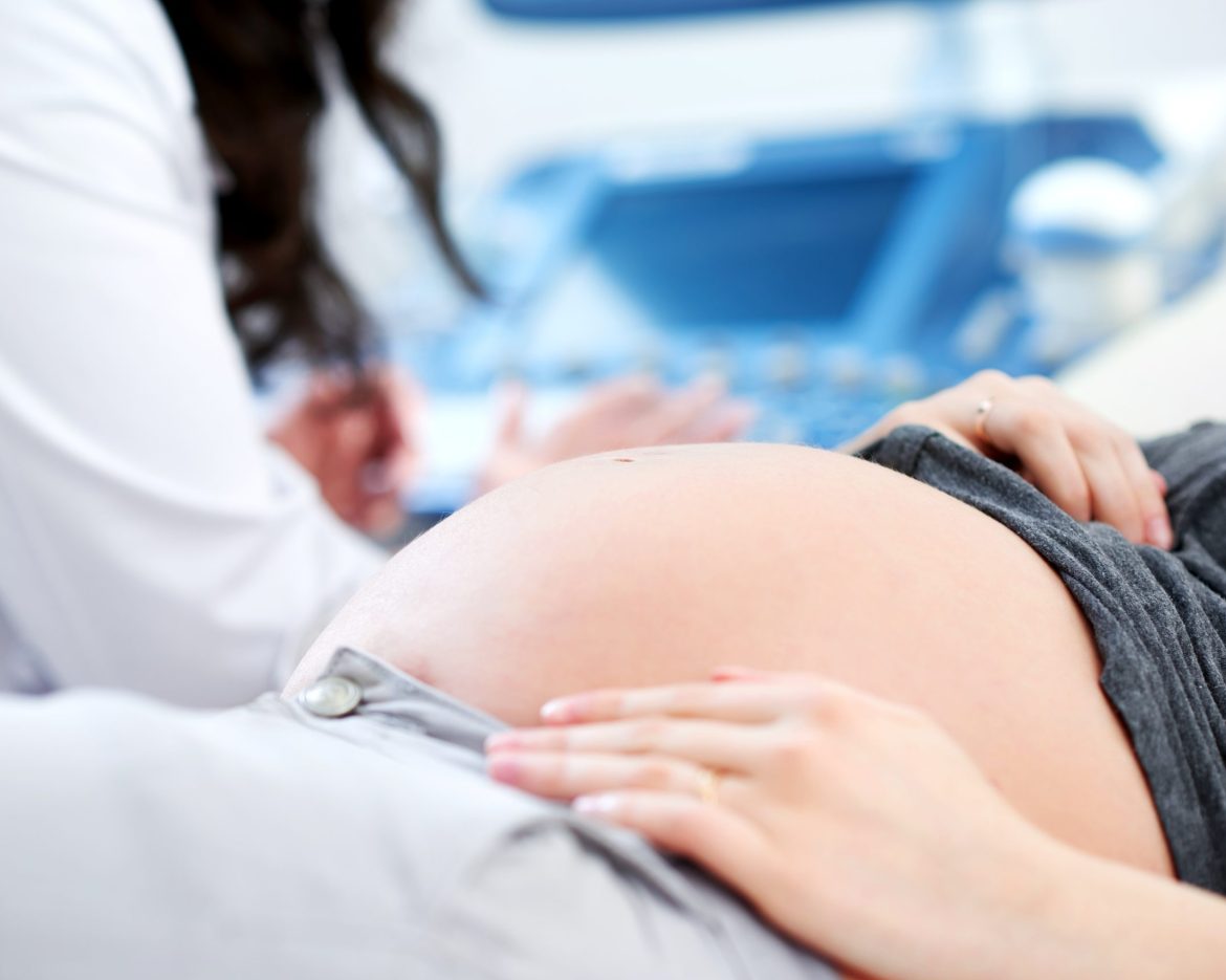 Doctor performing ultrasound scanning for her pregnant patient