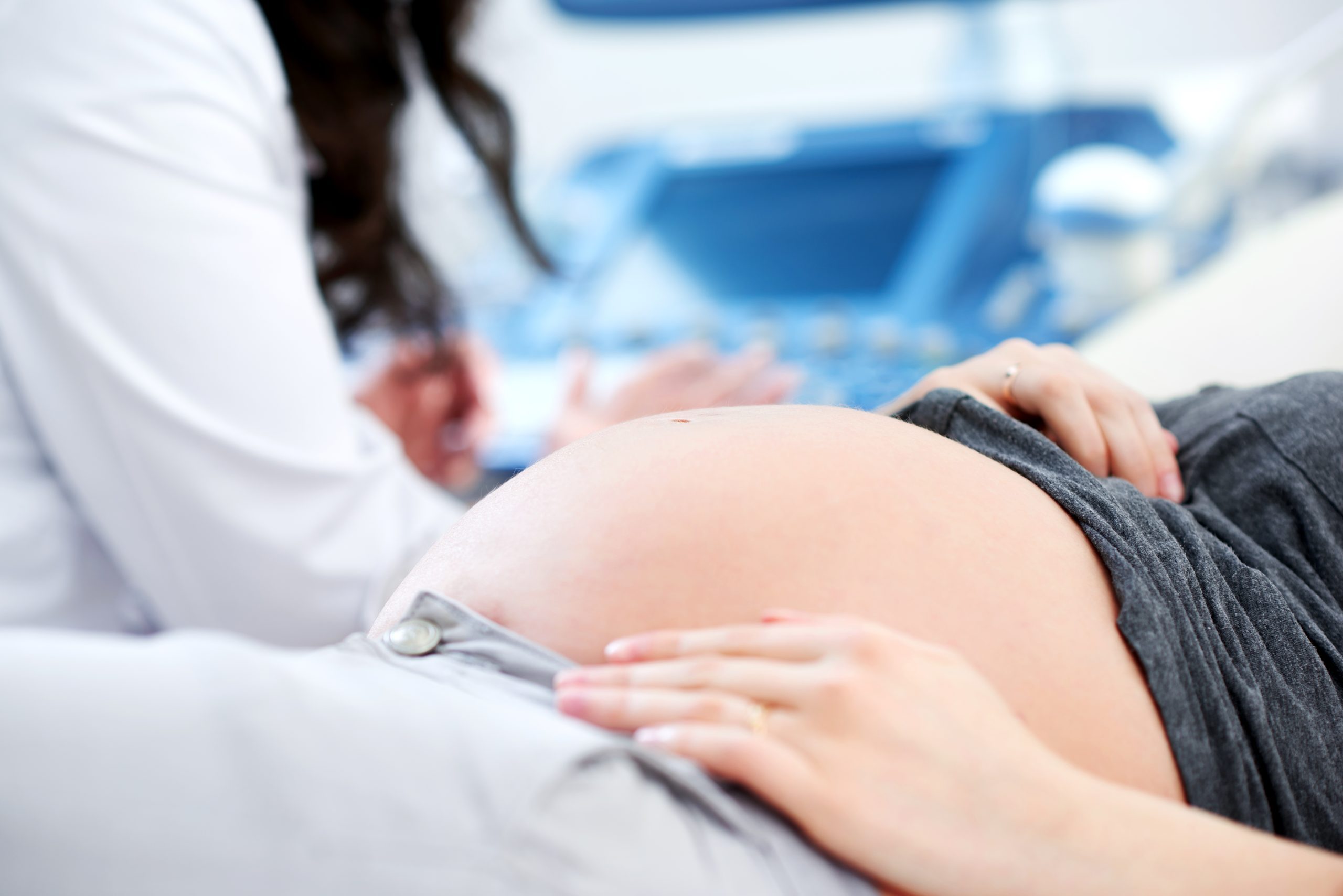 Doctor performing ultrasound scanning for her pregnant patient