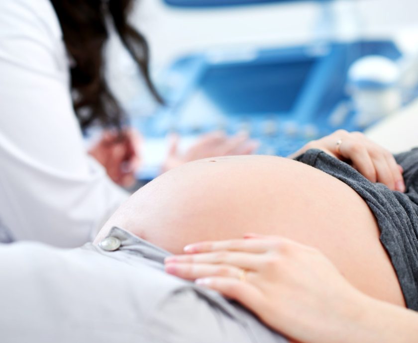 Doctor performing ultrasound scanning for her pregnant patient